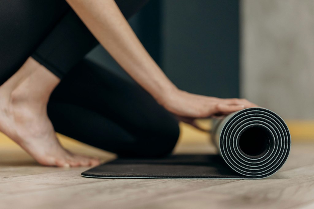 Woman rolling out her yoga mat