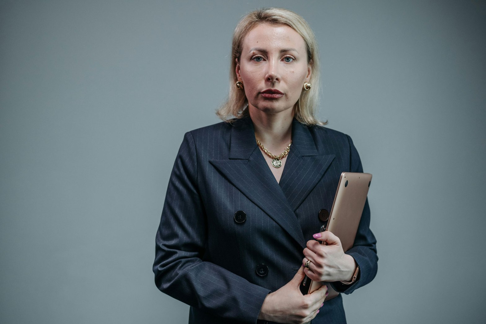 Midlife woman holding on to a laptop, reflecting stress and anxiety.